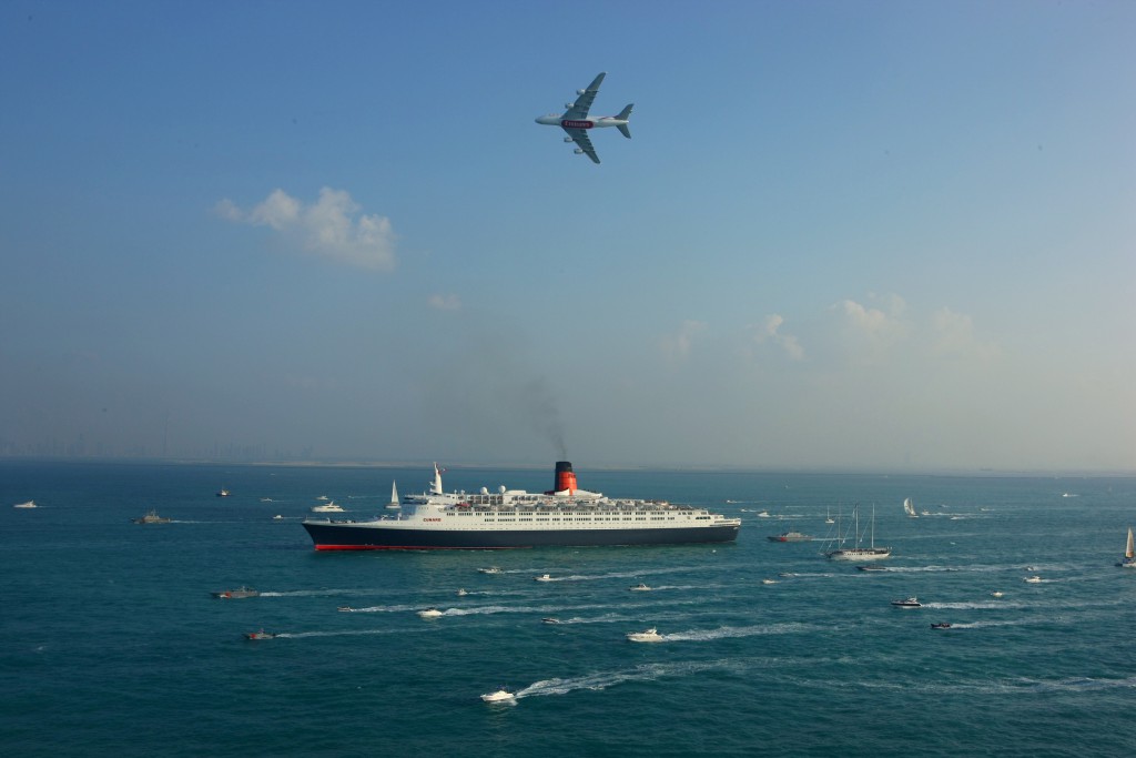 QE2 arrives in Dubai joined by an Emirates A380 Airbus and a flotilla of over 60 local yachts, boats and leisure-craft